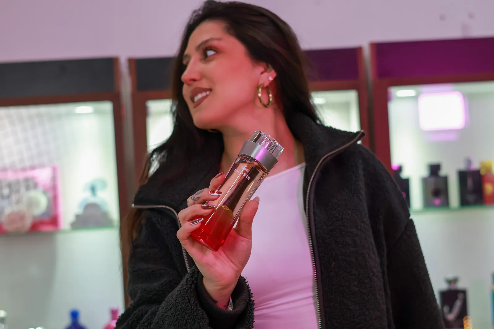 Integrante del equipo de Esencia Moderna mostrando un perfume