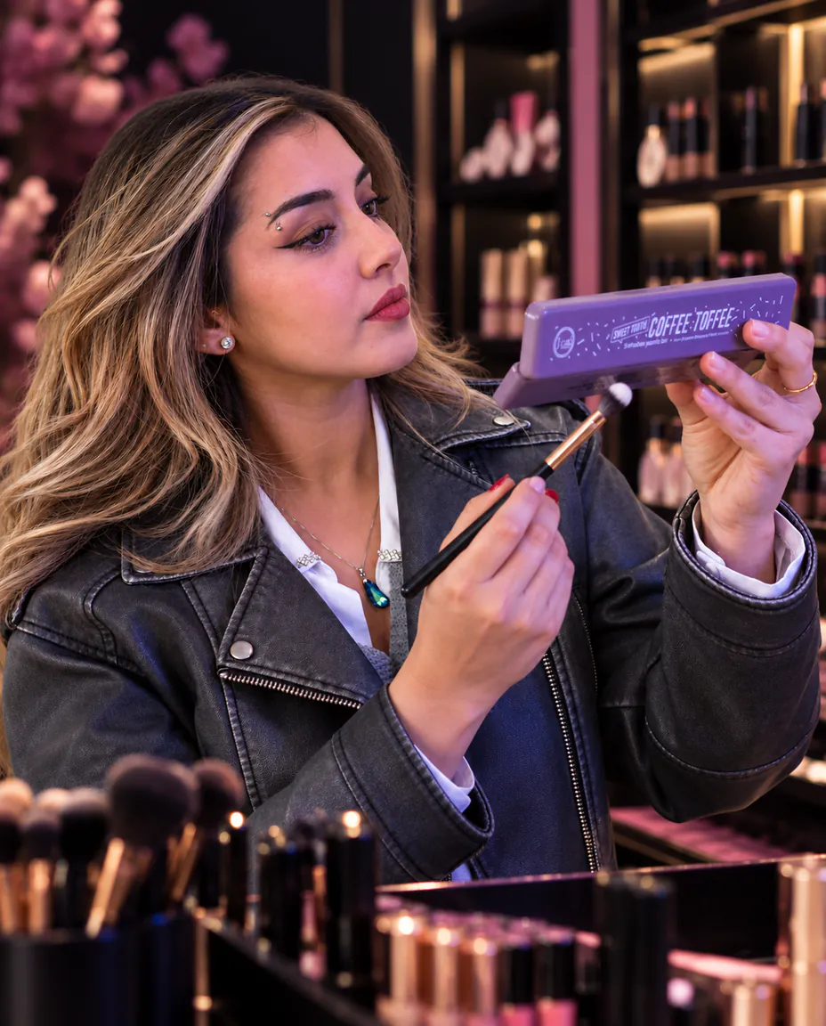 Clienta probando una paleta de cosméticos en Esencia Moderna